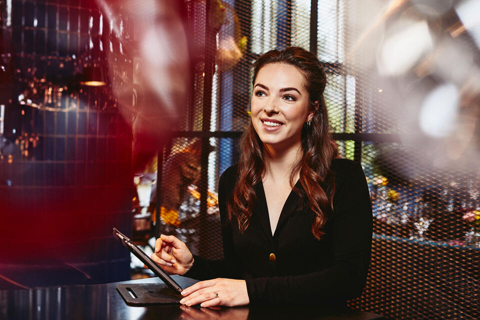 Randstad Operational Handel Smiling female looking away, behind the reception desk