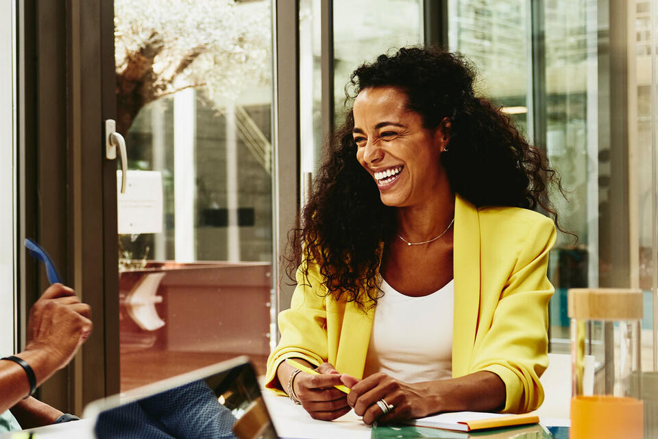 Randstad Professional male and female talking and having a laugh at the office