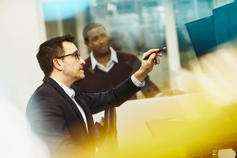 Two men working together in an office Two men working together in an office
